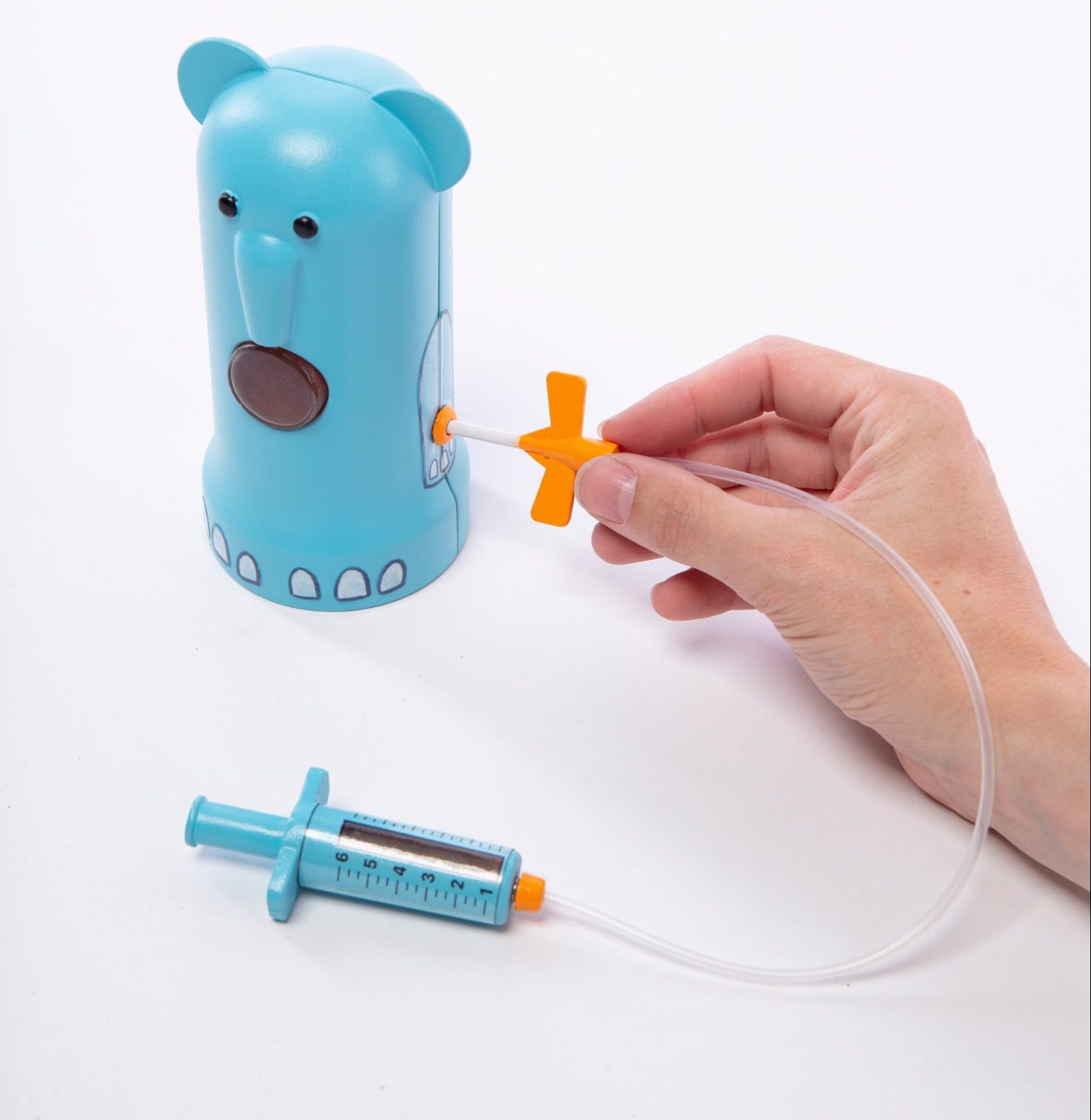 Photograph showing children's toy with mock syringe, tube and blue bear