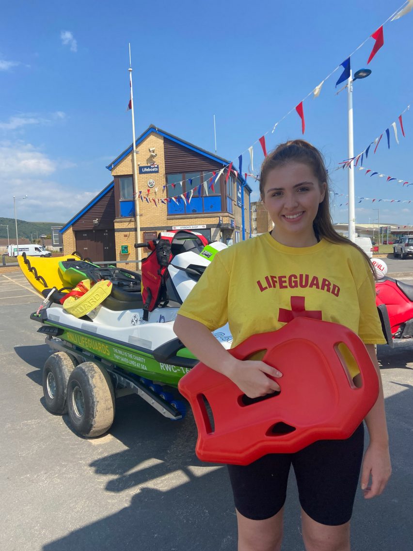Photograph showing lifeguard holding red life float