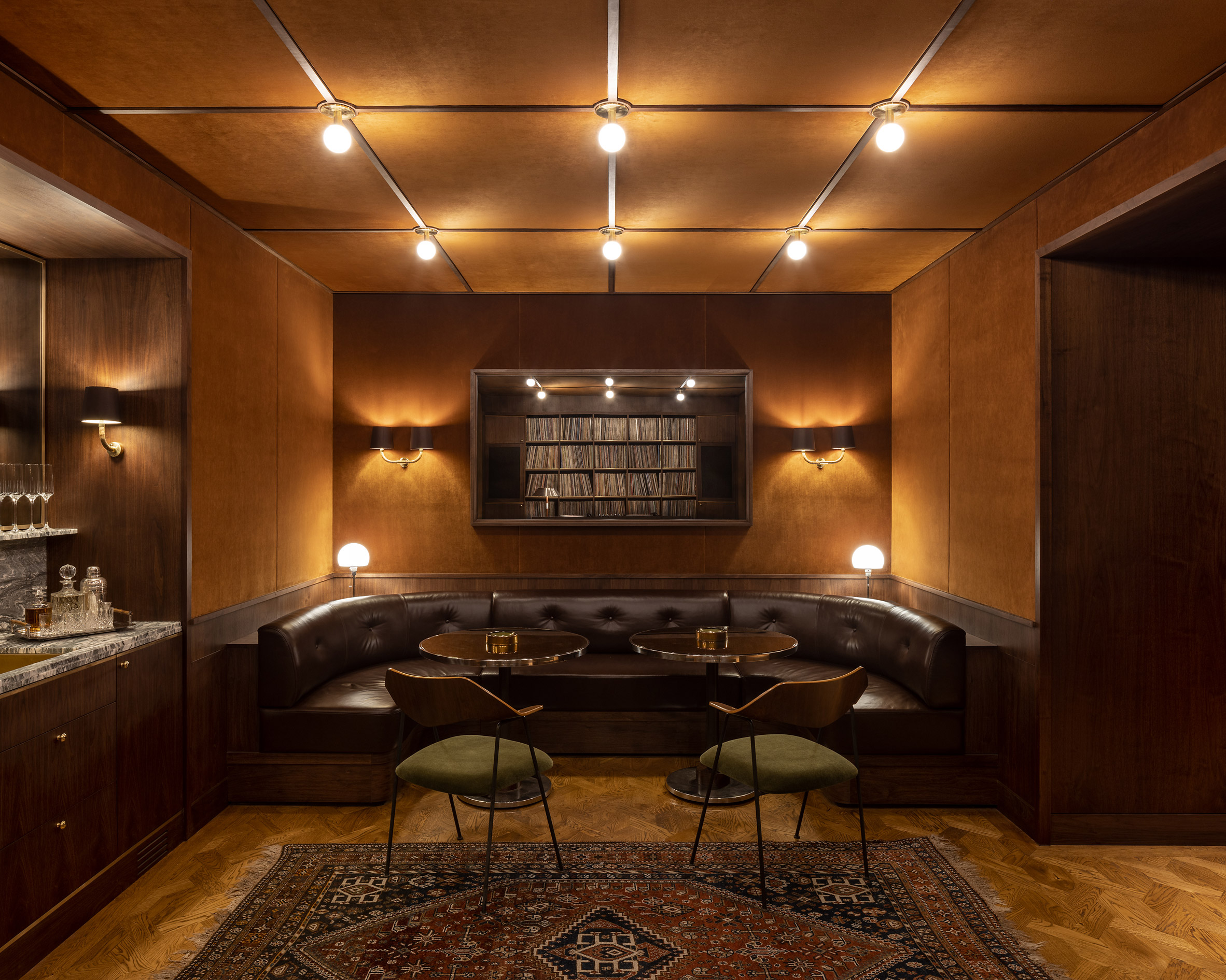 Dark lounge space and bar with vinyl collection by designer Sarita Posada