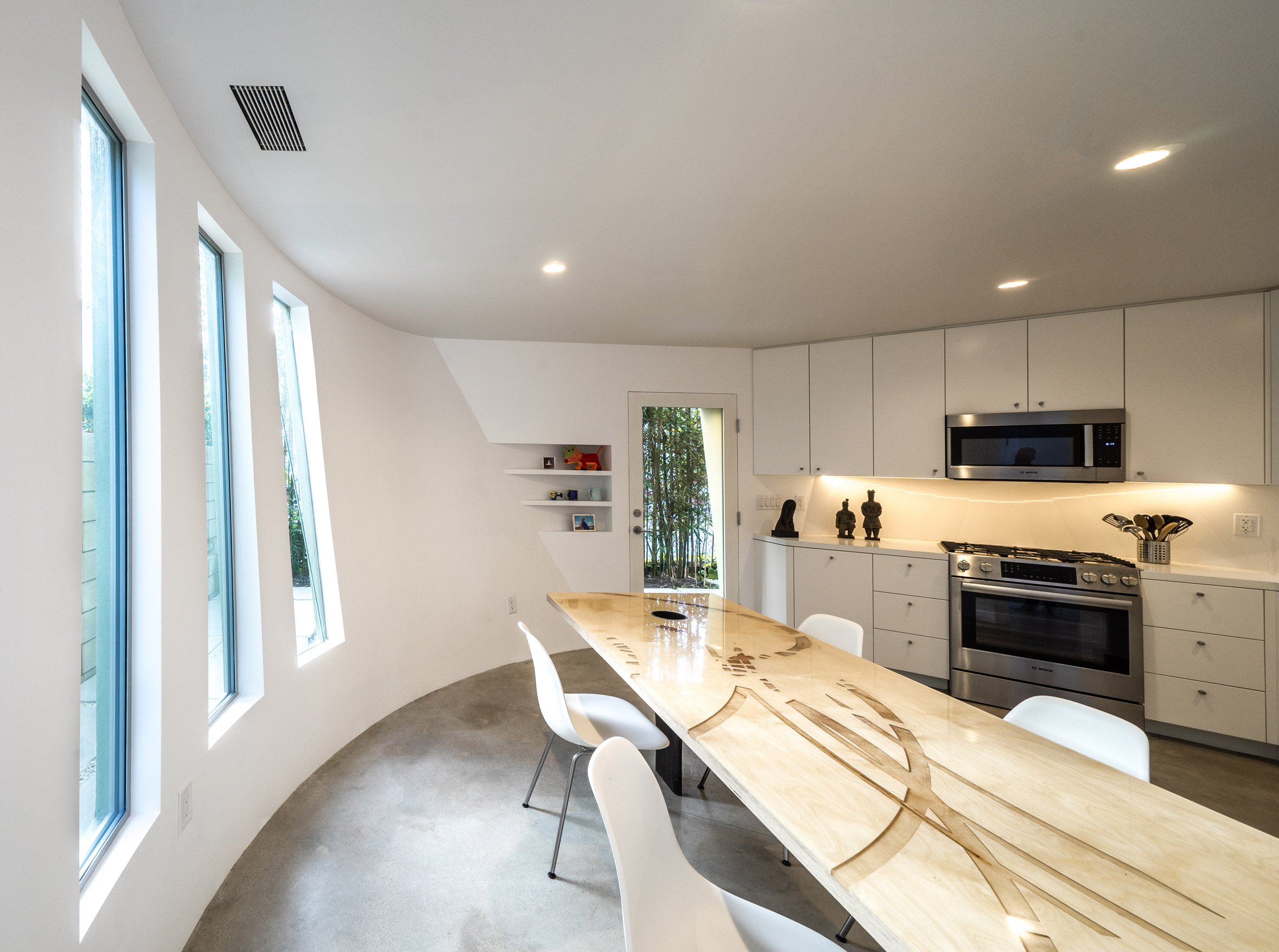 Curved kitchen and dining space by Eric Owen Moss