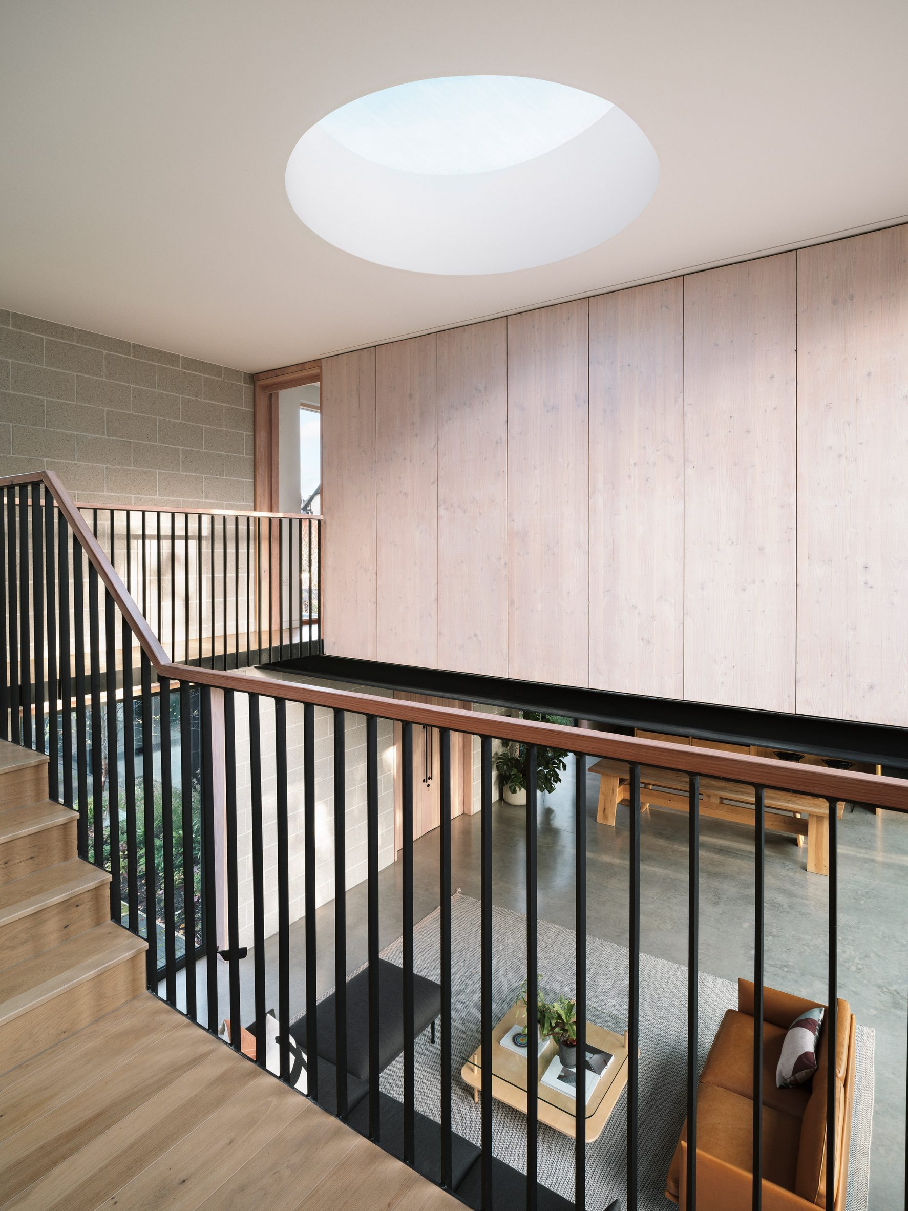 Circular roof light over a stairwell over a double-height open plan living space
