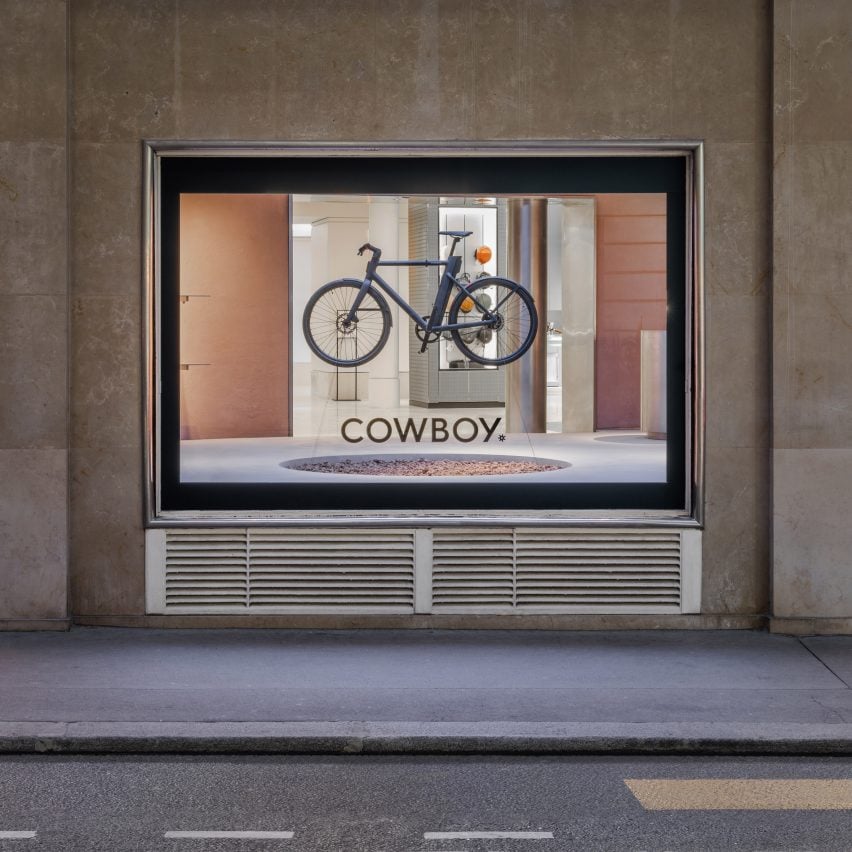 Exterior shop of bike hanging in window of Cowboy e-bike shop in Paris by Ciguë