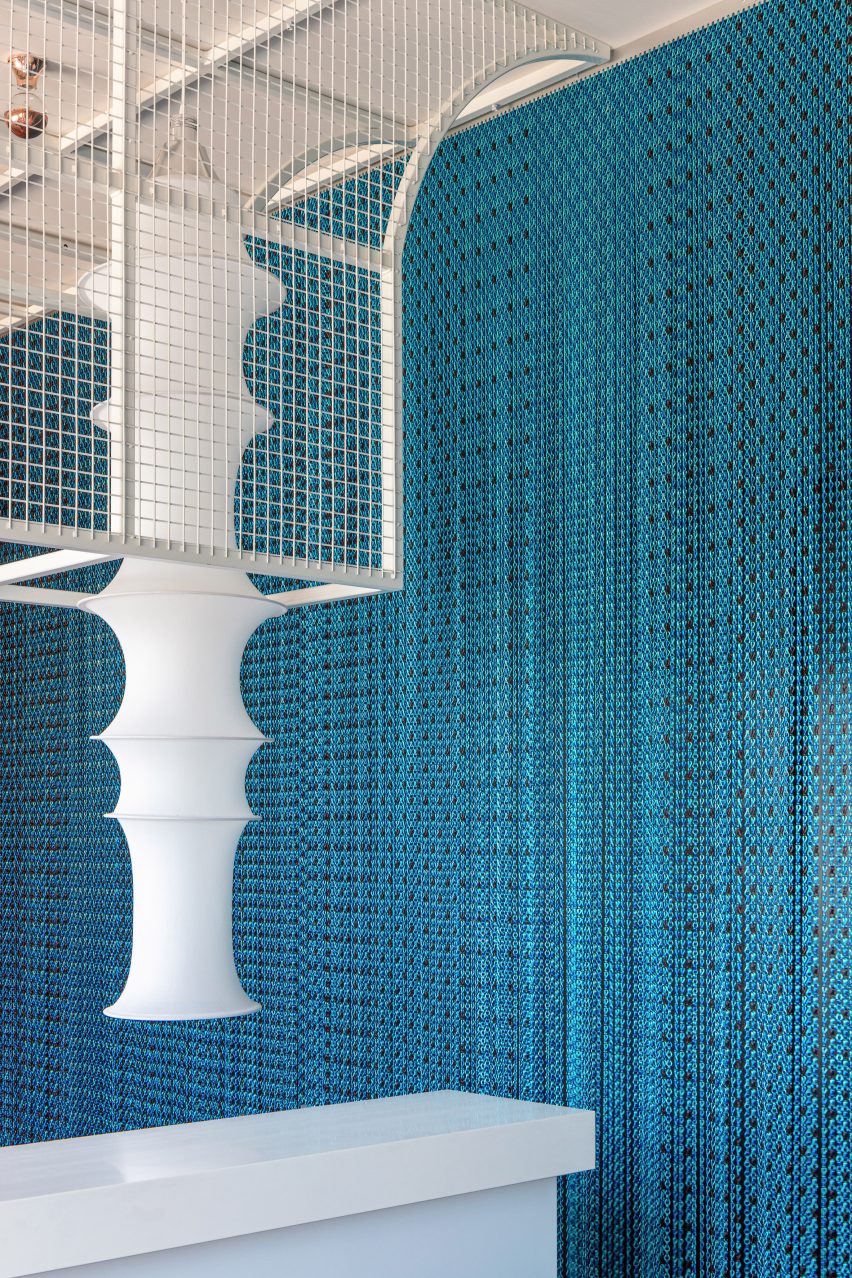 Light blue curtain in cocktail bar with white caged lamp