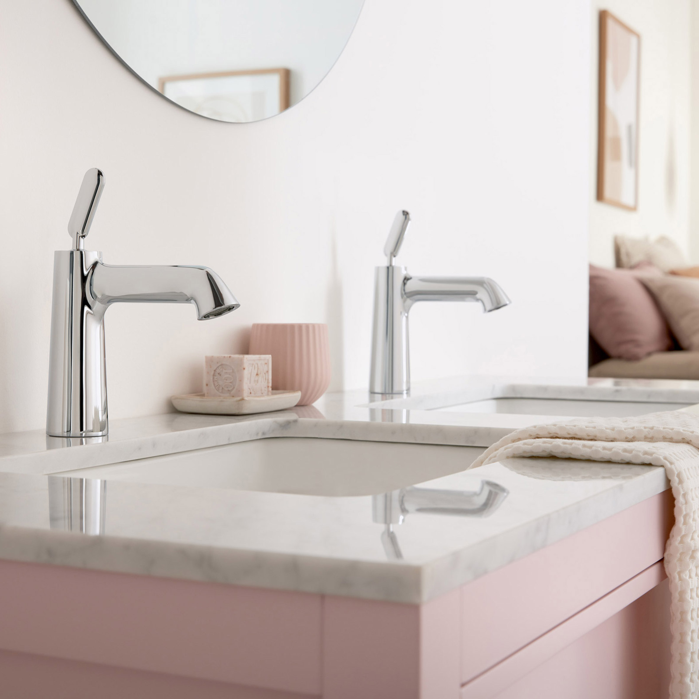 Two silver Arrondi taps on a pink sink