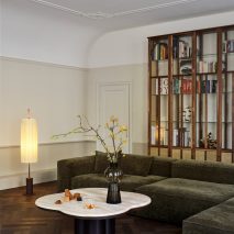 Living room of Home Dijkhuis by Studio Modijefsky with green sofa large timber bookcase