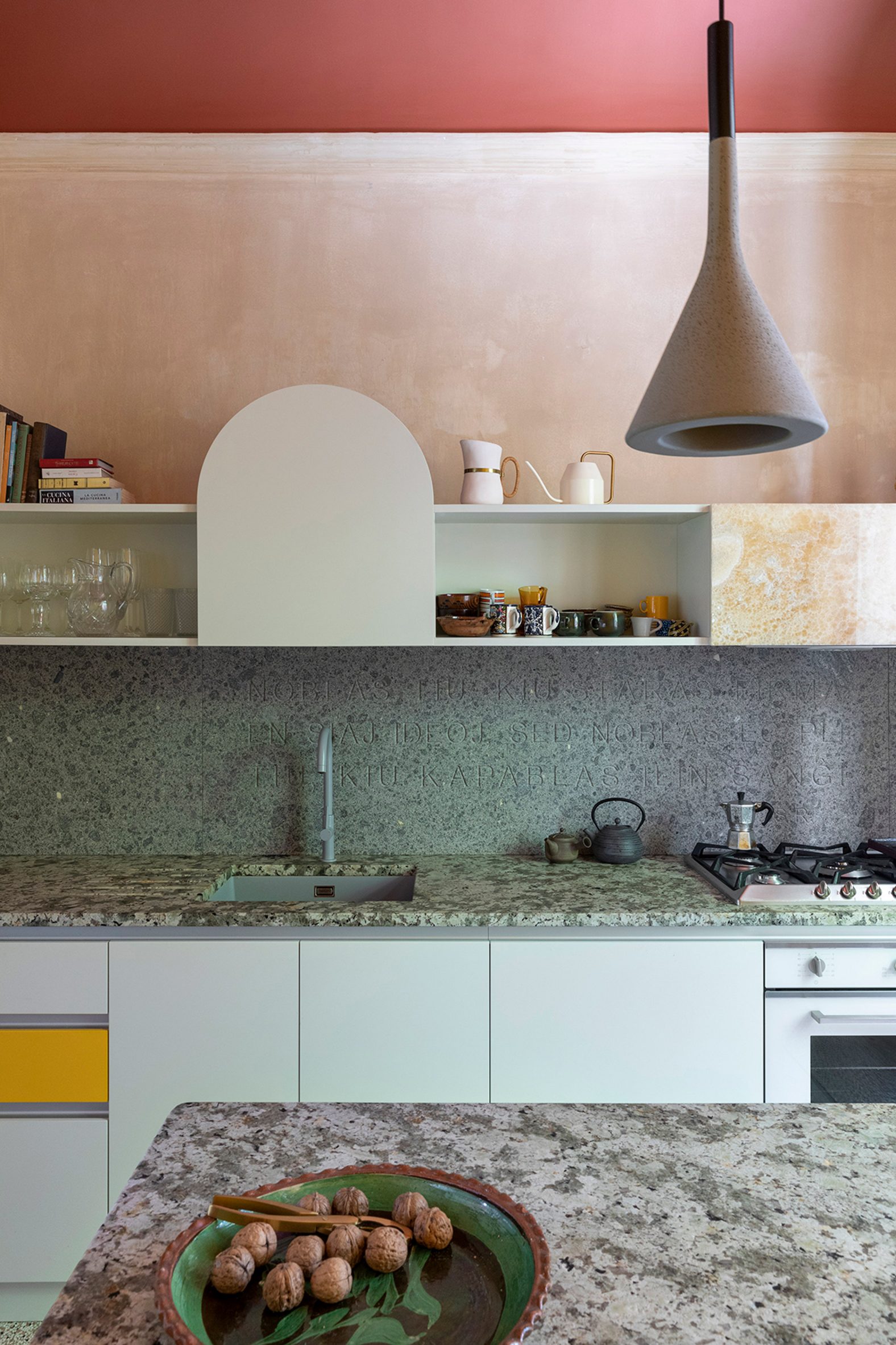 A colourful kitchen with grey granite worktops