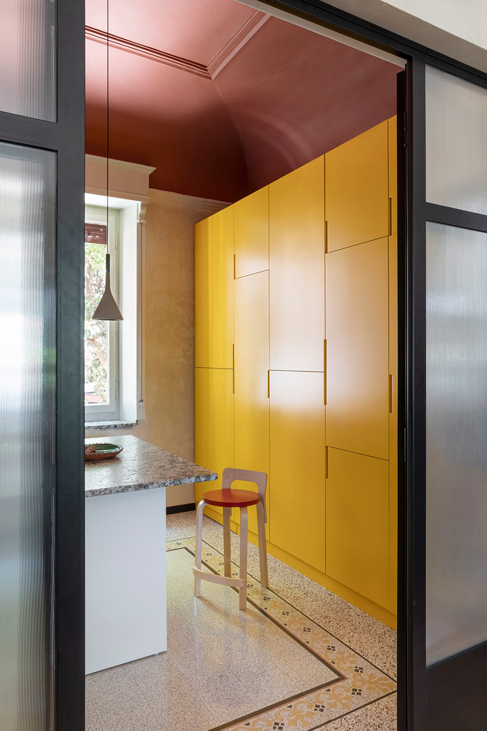 Kitchen with terracotta red ceiling and yellow wall units