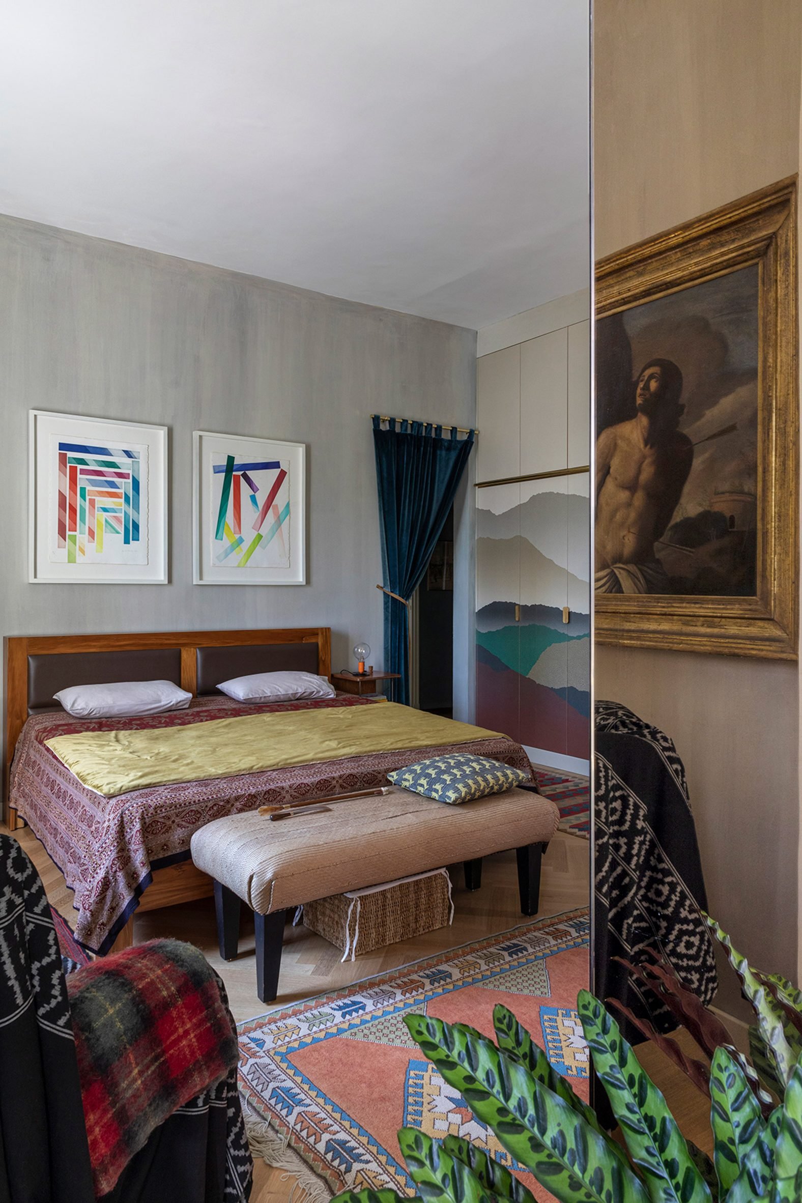 Bedroom of Rome apartment by 02A with mirrored walls and various artworks on the walls