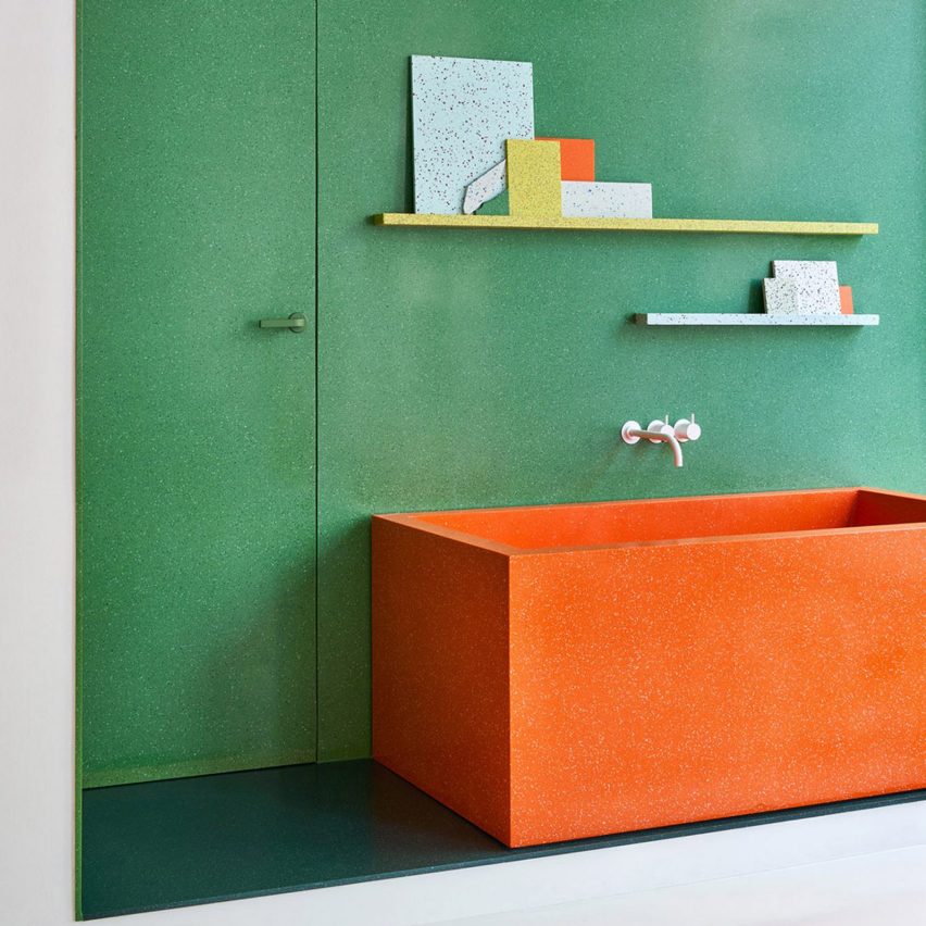 Orange wash trough against a green wall in the Durat Helsinki showroom