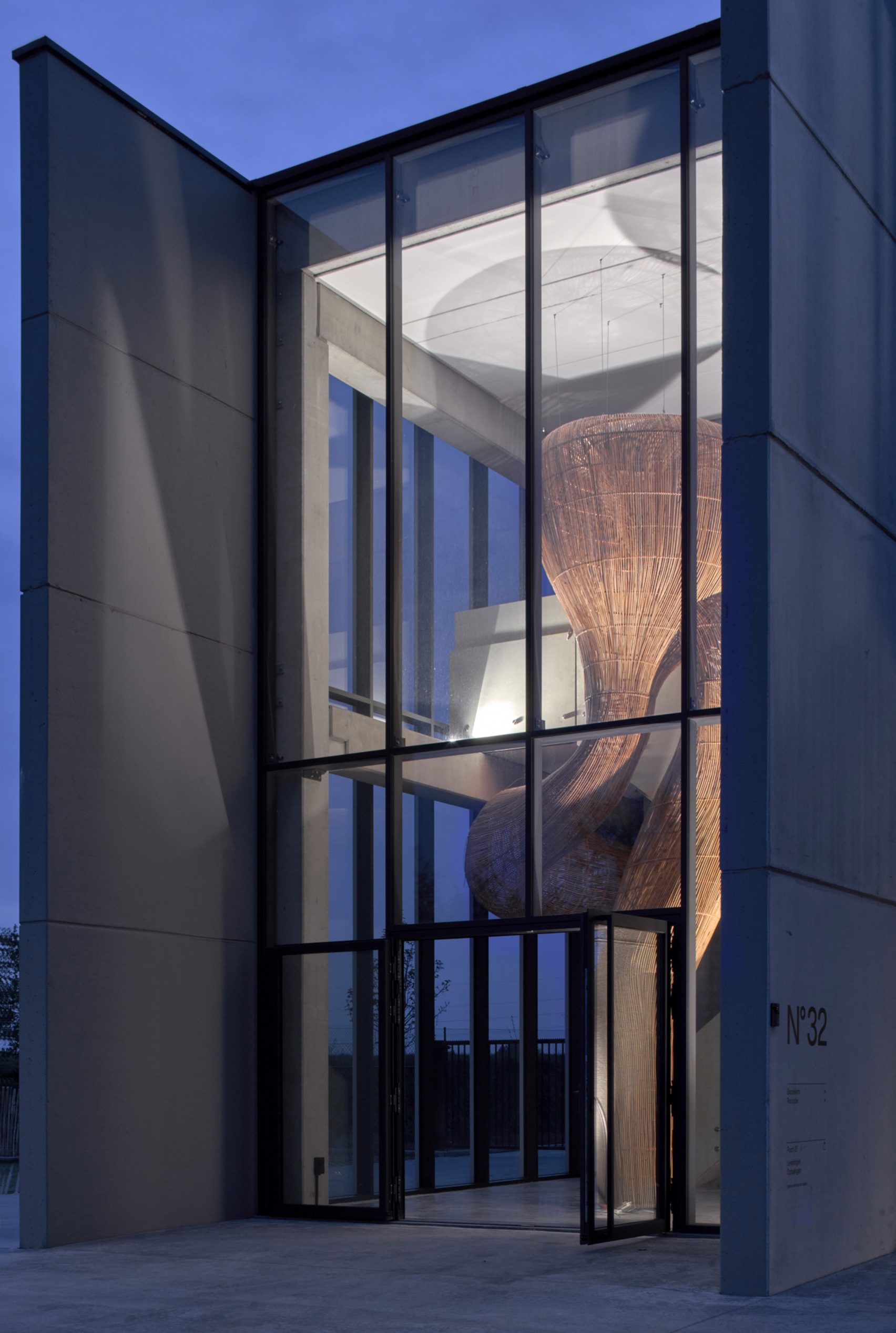 Rattan sculpture through large glass windows of Belgium office by Enter Projects Asia