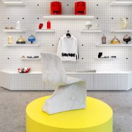 Taburete Fabio Novembre sobre pedestal amarillo en la Galería IoNoi de Milán