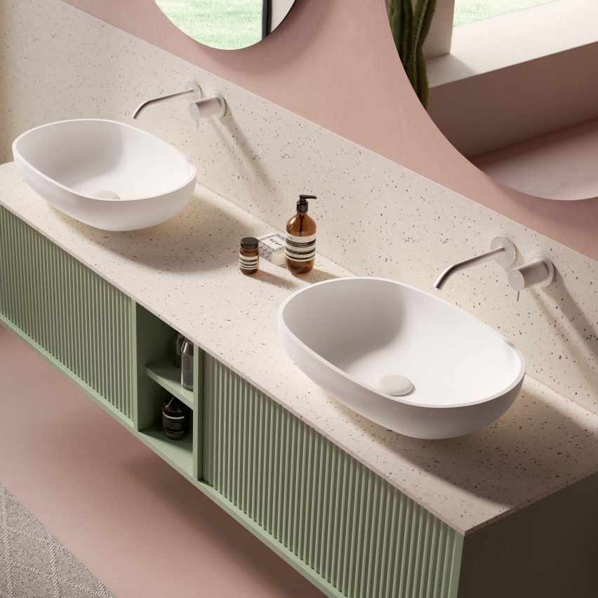 Two oval top-mounted sinks on a green bathroom cabinet