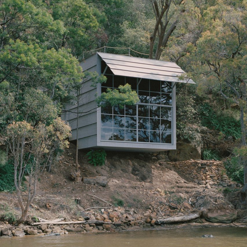 Image of the Marramarra Shack perched on the bank of the sloping stream