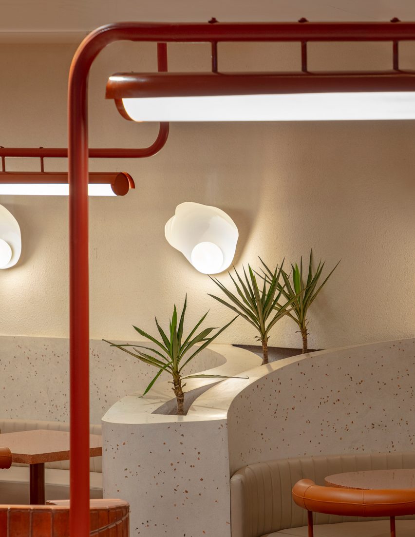 A white wall lamp and plants inside a cafe