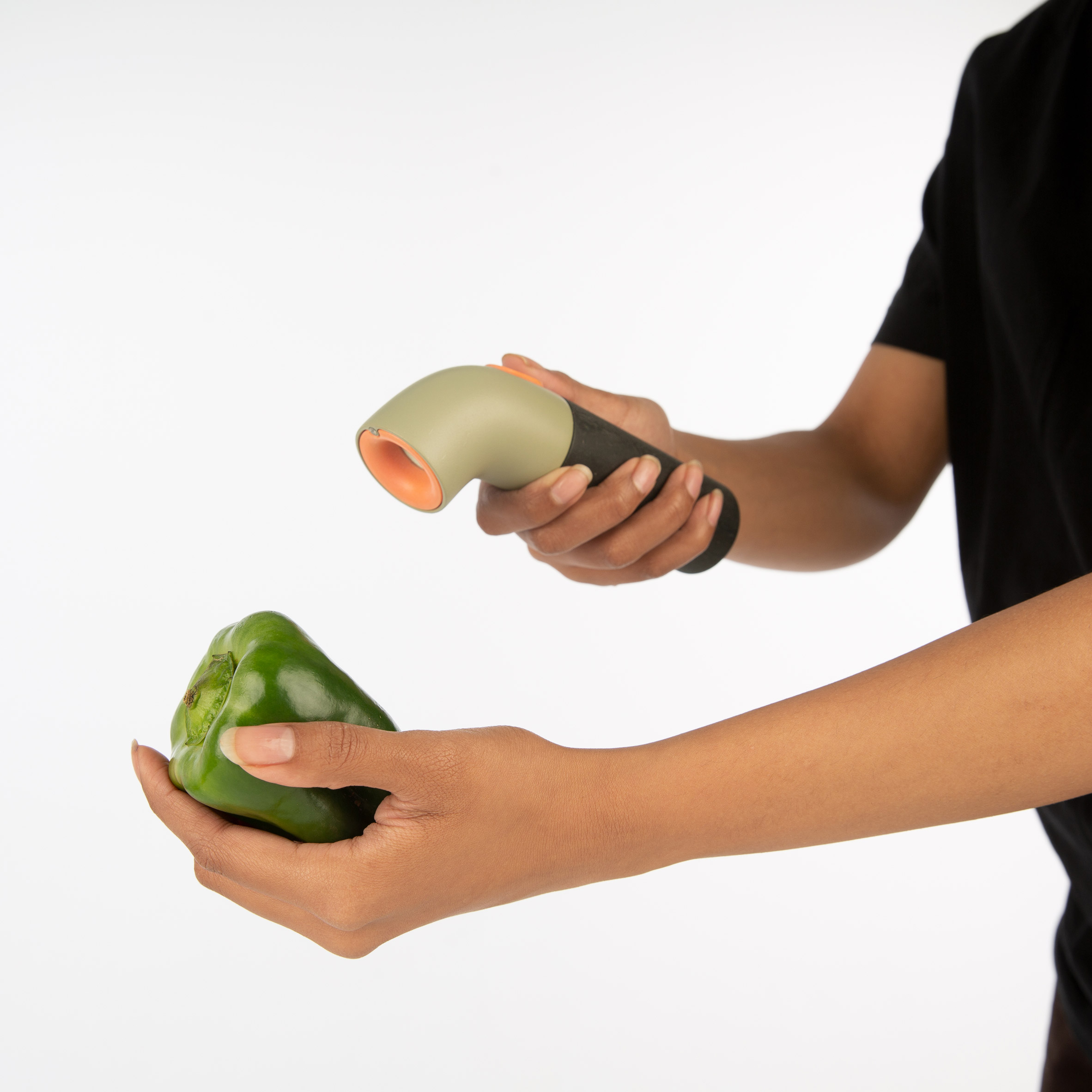 Hand holding an aroma detector up to a green pepper