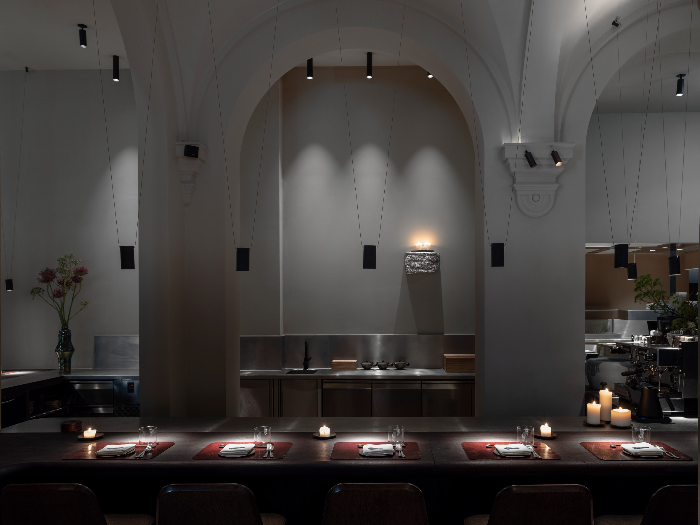 Candles illuminate dining spaces in dark Antwerp restaurant