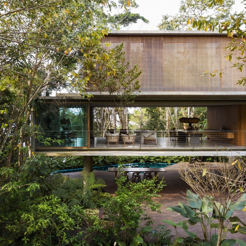 Casa Azul by Studio MK27 with glazed sliding doors on first floor open for a through view of the forest