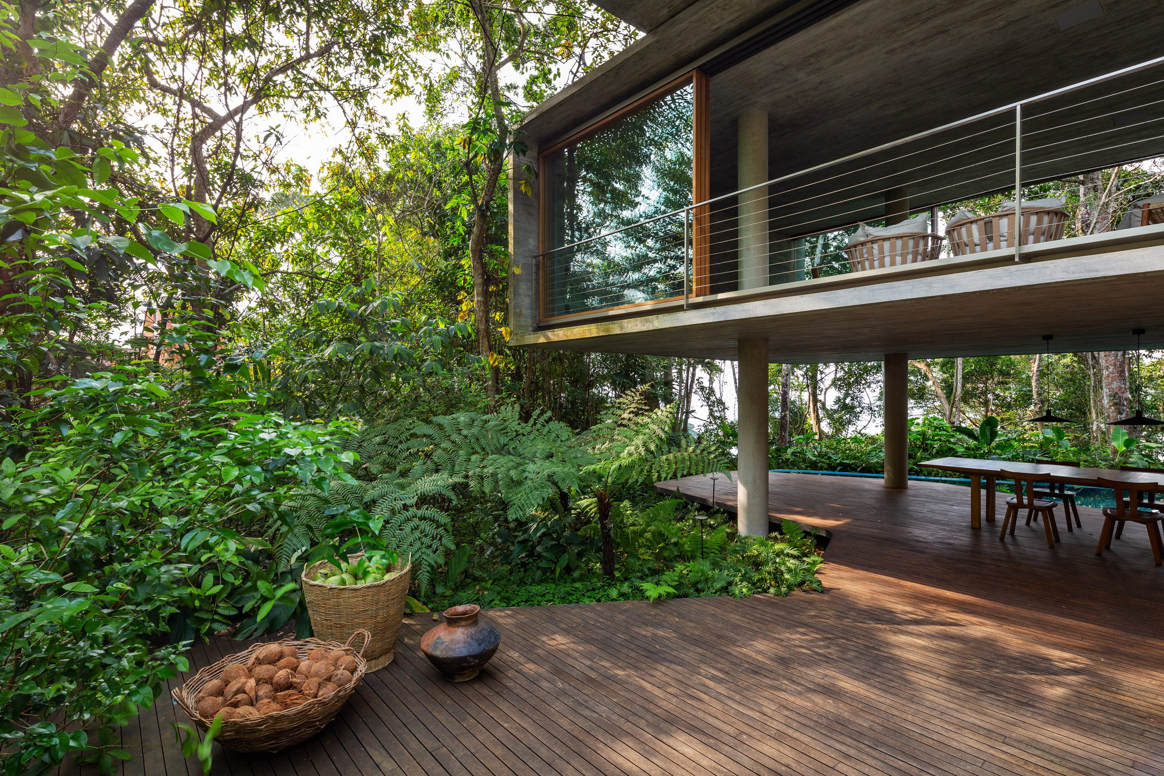 Wooden decking over rainforest floor with Casa Azul raised on concrete pilotis