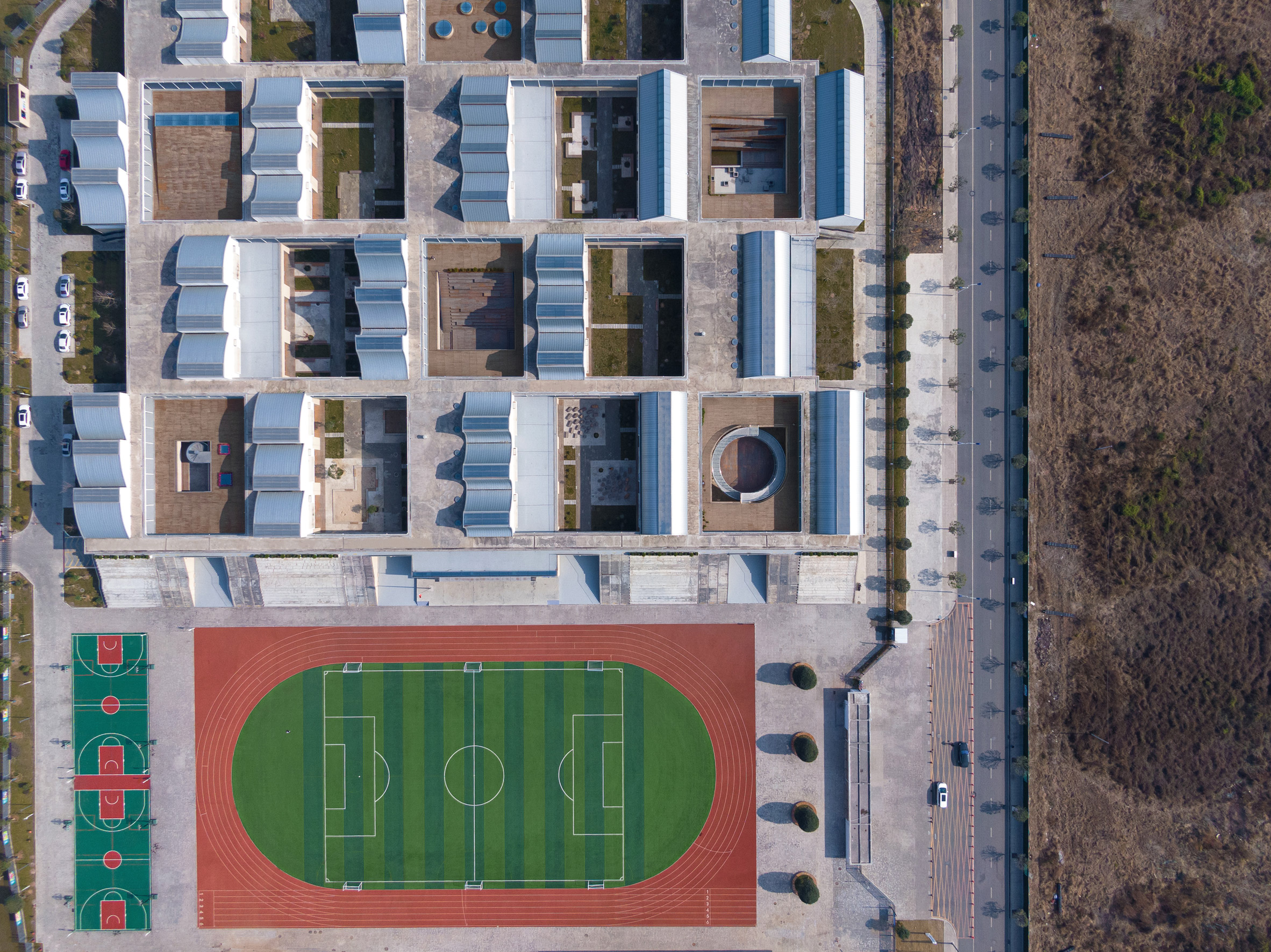 Aerial view of elementary school with mixture of roof shapes and football pitch