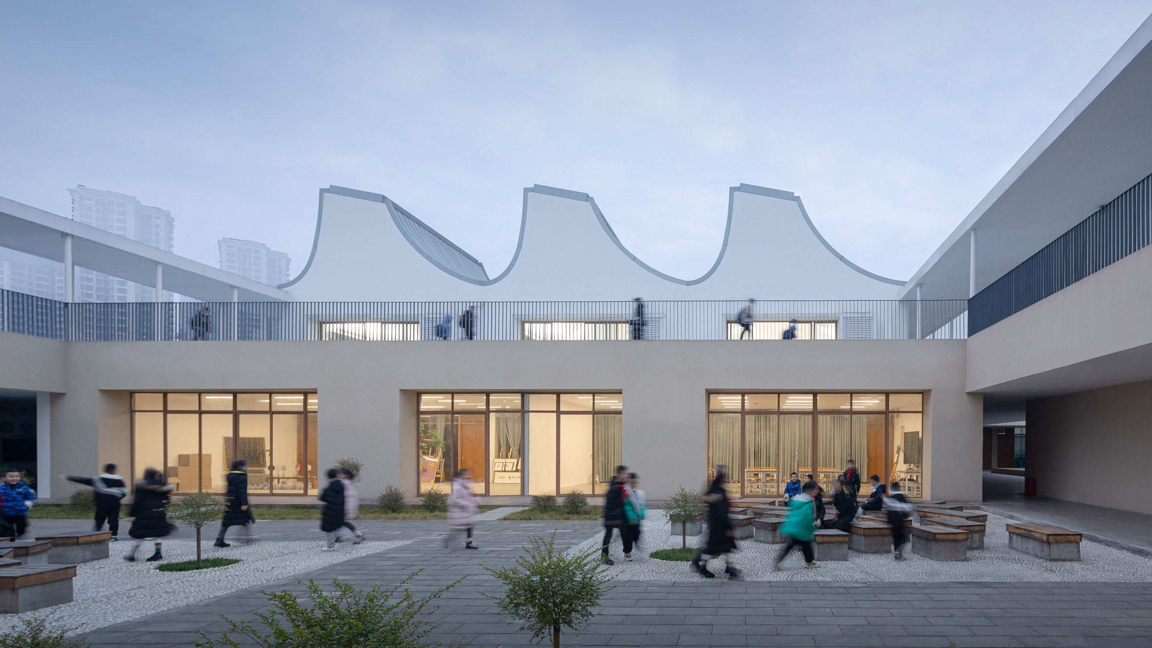 Curved roofs over classrooms around central courtyard in China elementary school by Trace Architecture Office