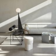 Zona de estar de la cafetería Orijins de VSHD Design con sofá blanco y sillas de metal negro