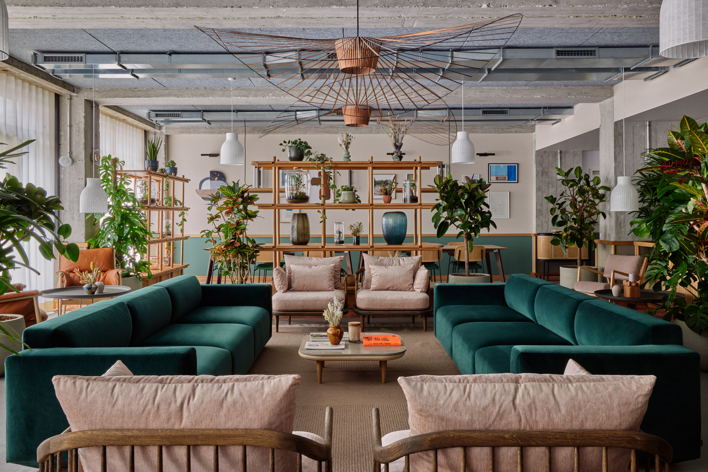 Seating area with blush pink and sea-green seating in Munich hotel by Holloway Li