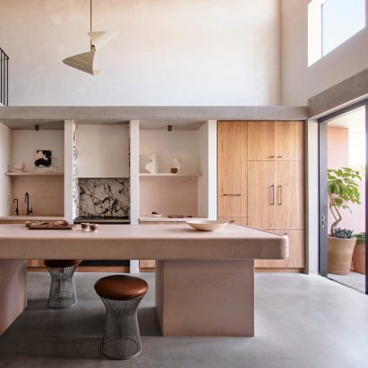 A kitchen that includes wooden tables and white walls