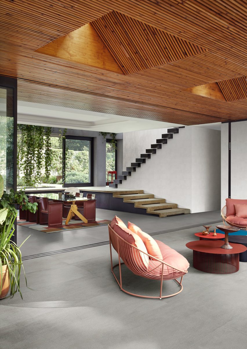 A photograph of the grey flooring Cementum featured in a living room with colourful seats