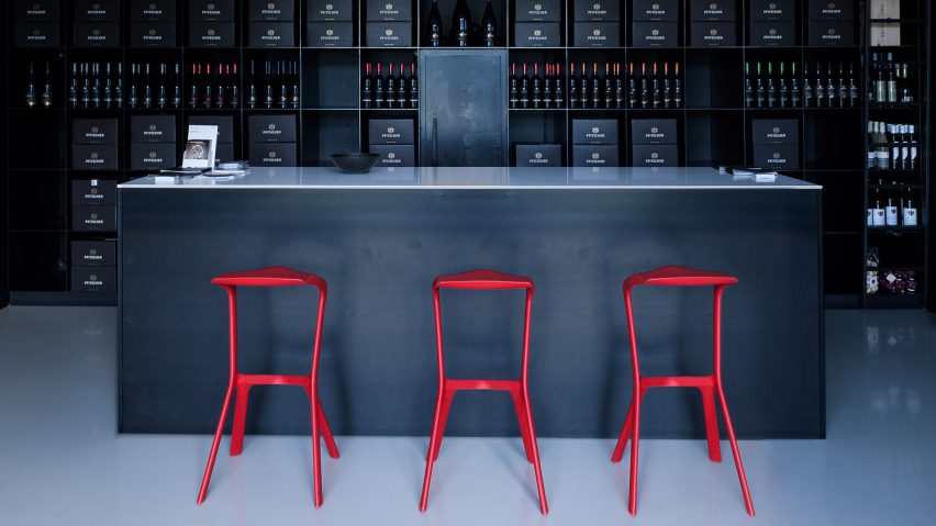 Red polypropylene stools lined up at a bar