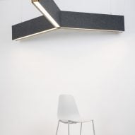 Photograph showing white chair beneath Y-shaped lighting fixture on ceiling