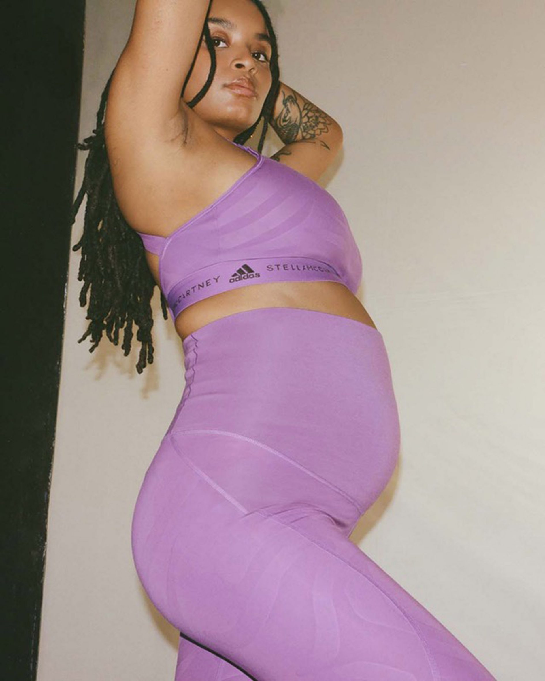 A woman wearing purple leggings and nursing sports bra