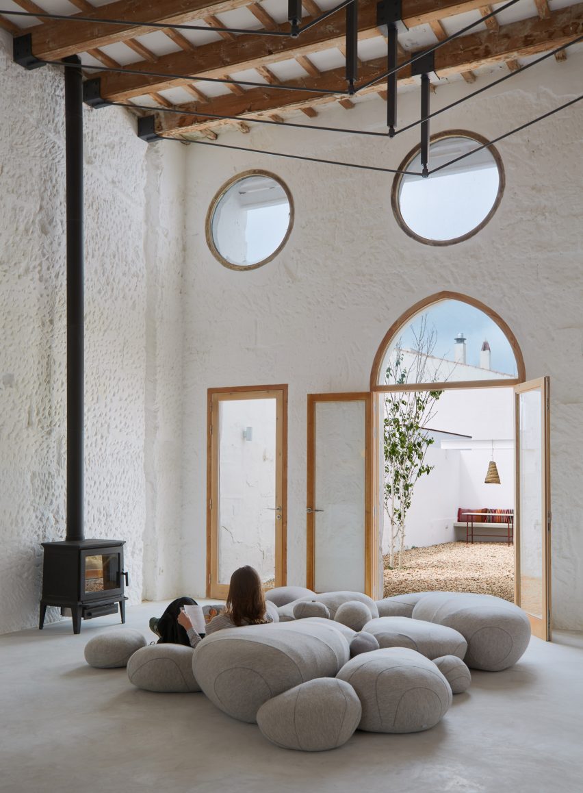 Woman sat on grey poufs in Artchimboldi Menorca creative retreat
