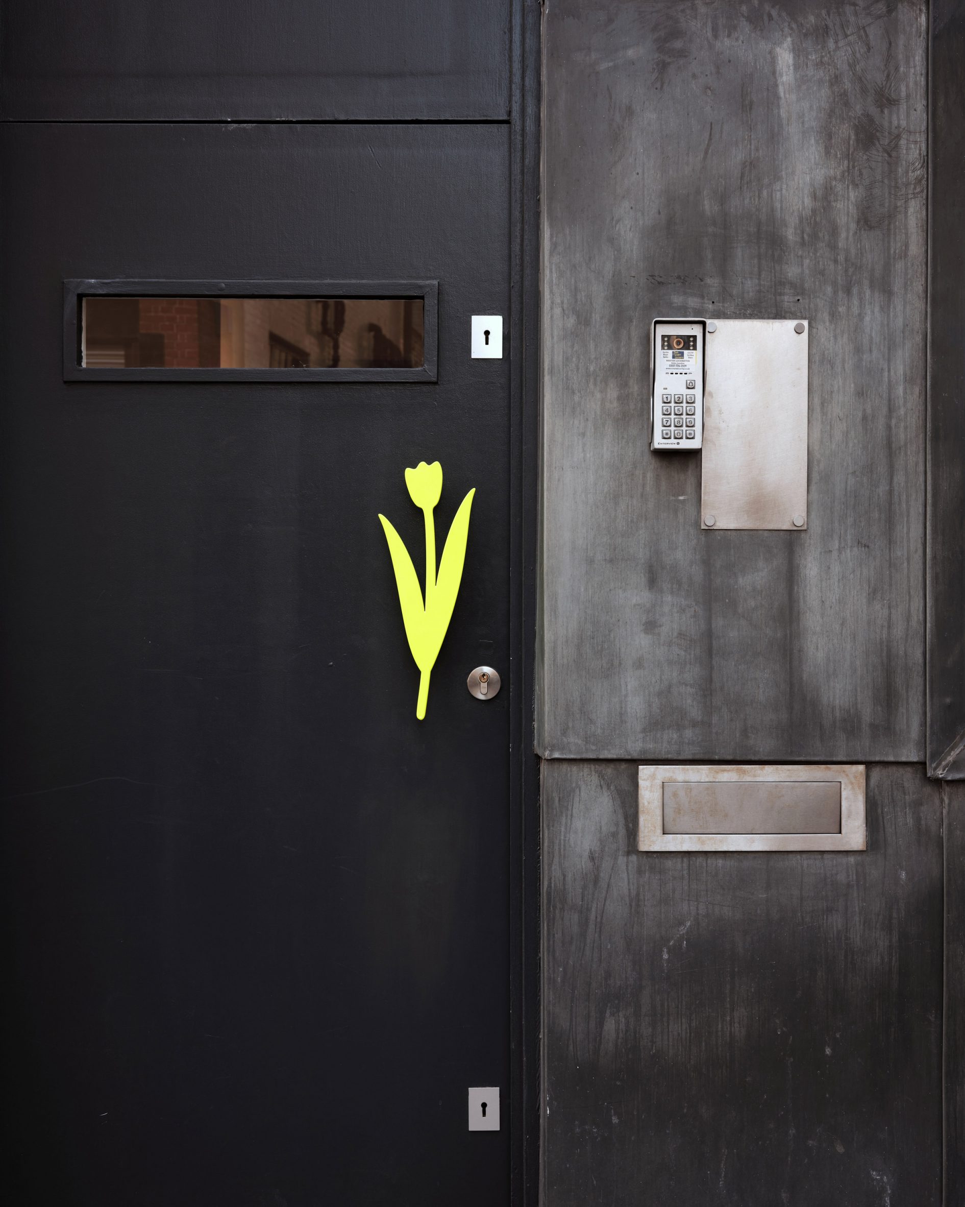 Exterior of yellow tulip-shaped door handle of the Ask Us For Ideas office