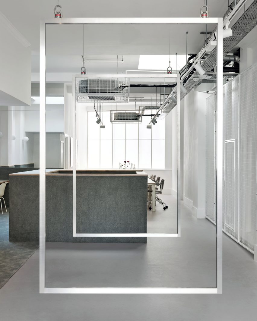 White office space with glass interior walls and grey carpet-lined counter