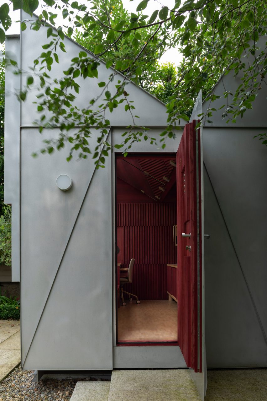 Triangular aluminium exterior surrounding red timber interior of The Writing Room by Clancy Moore Architects