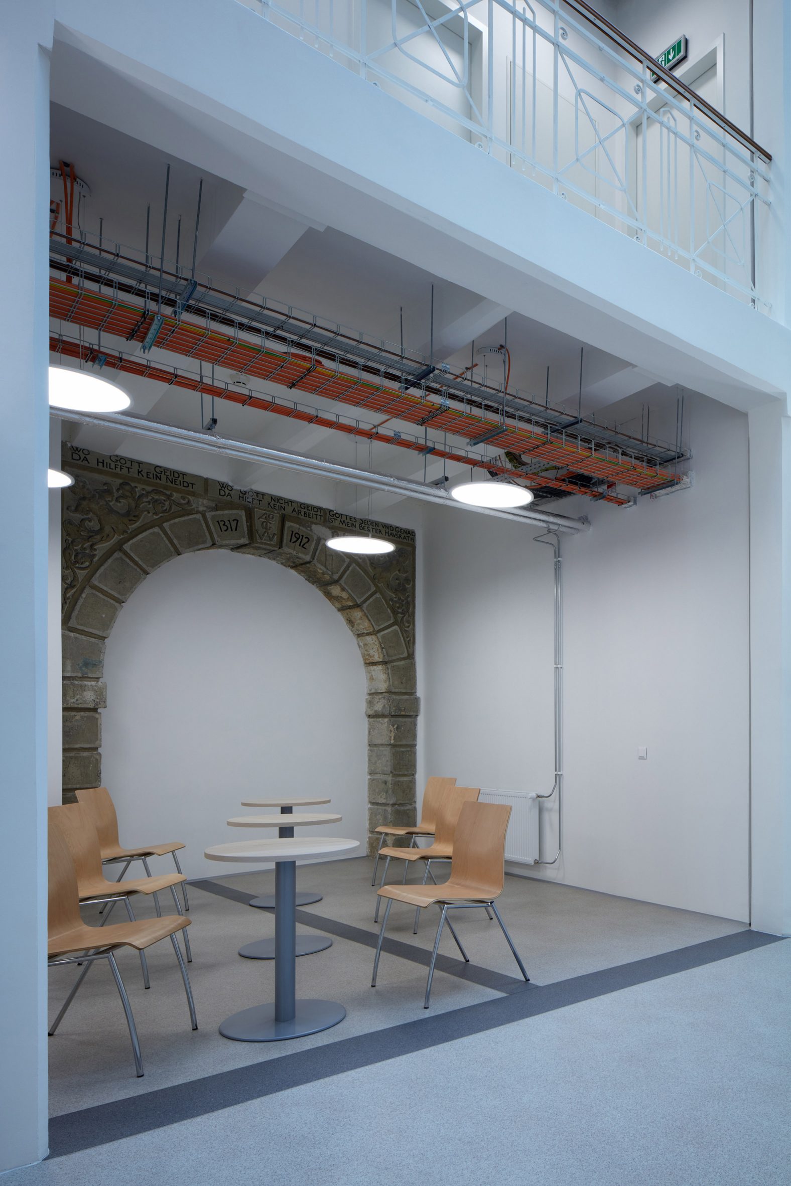 Photograph showing neutral-coloured meeting space with original archway detail inset into wall