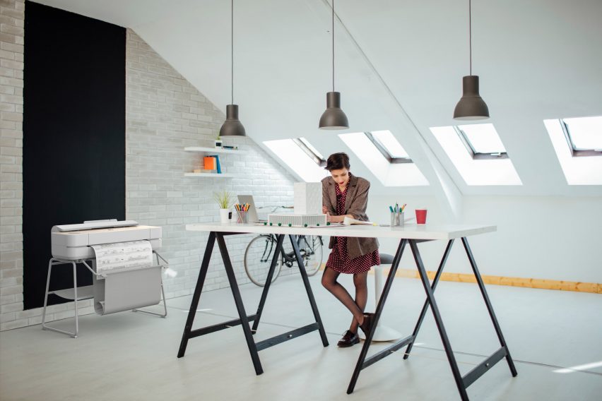 Designer at standing desk under pendant lights