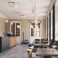 Stoly, designové židle a kamenné podlahy v kavárně Designmuseum