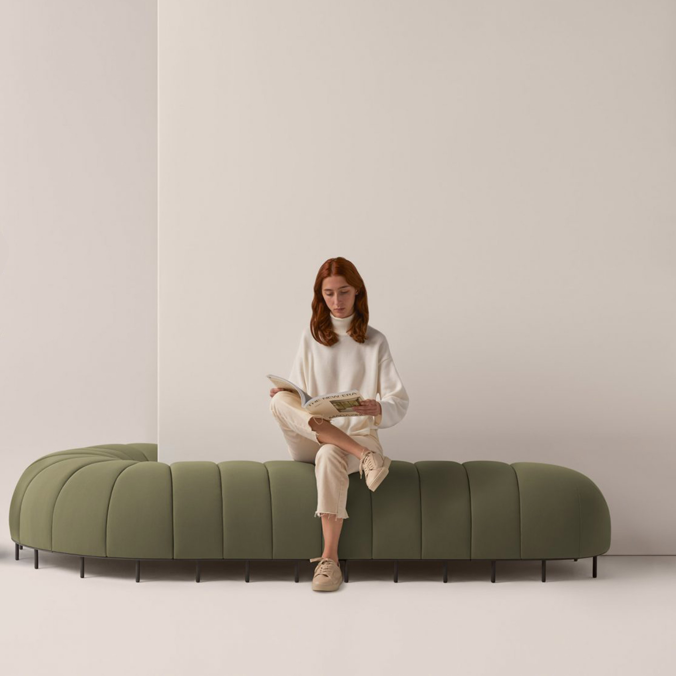 Green Worm sofa curving round a wall