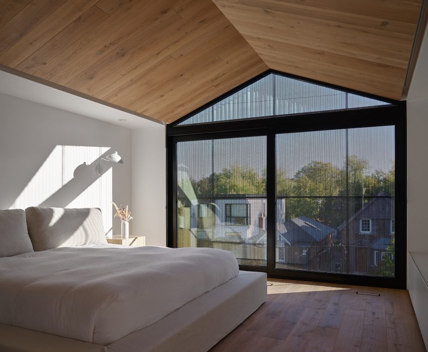 Bedroom with black mesh curtain in window and pointed oak ceiling