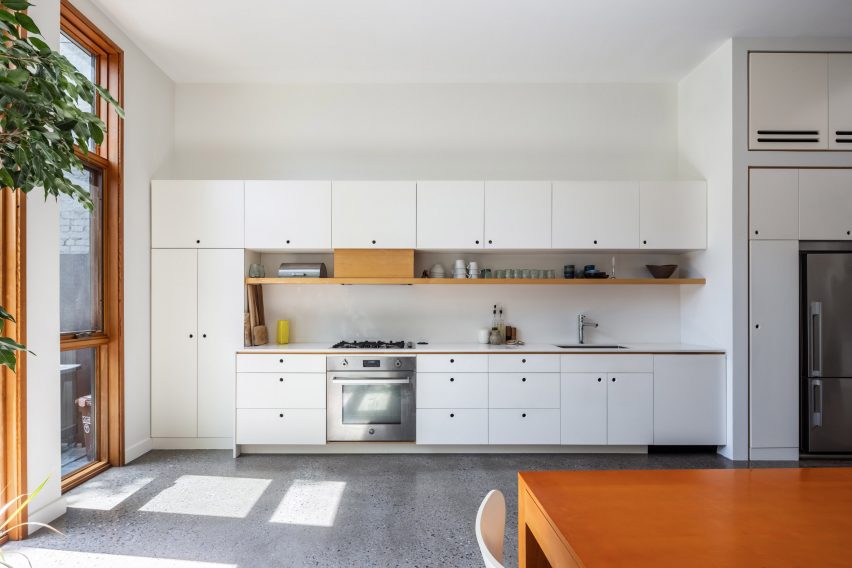 Cabinets along white wall of kitchen in Brooklyn townhouse