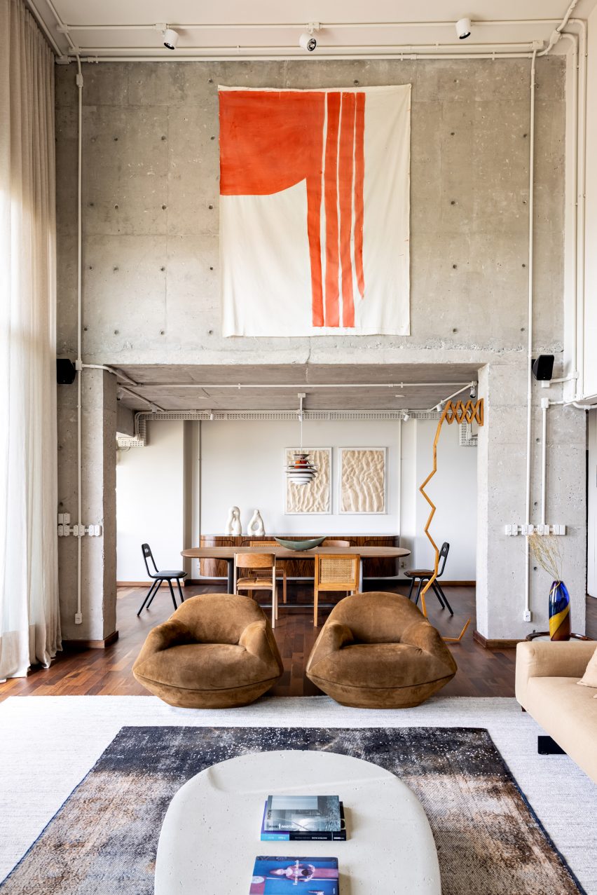 Gale Apartment living room with brown lounge chairs and concrete walls