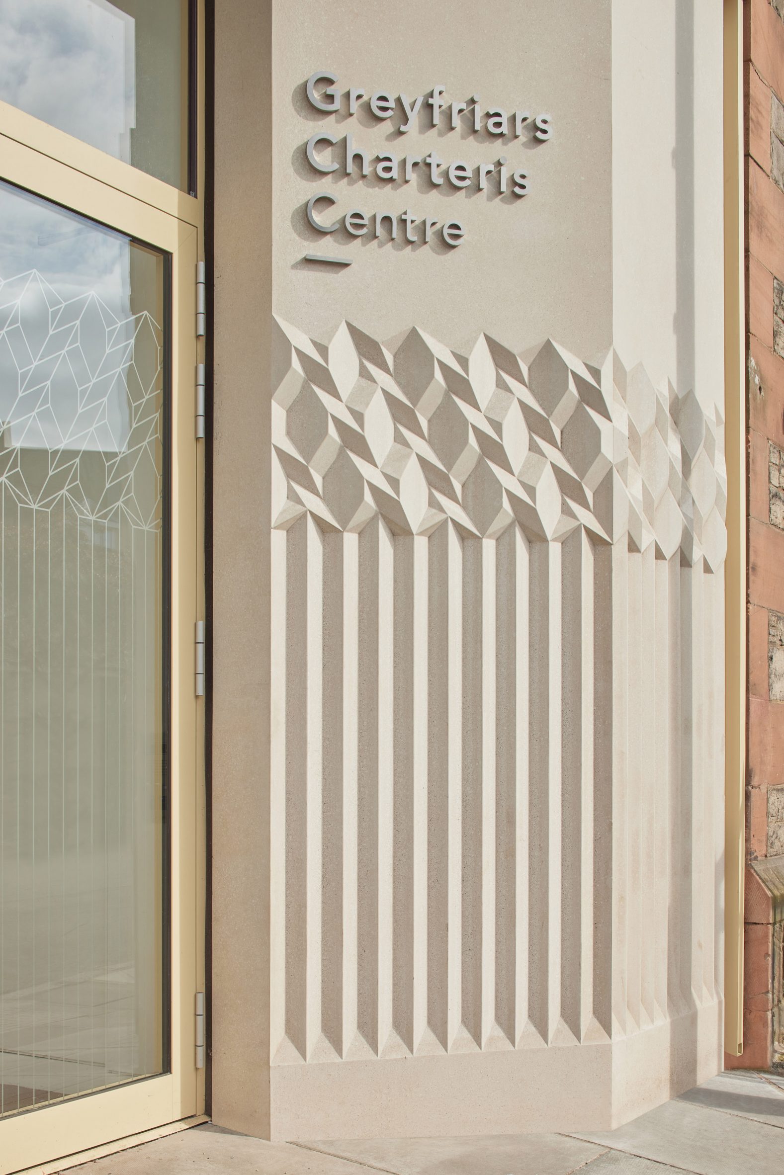 Photograph of carved terrazzo detail outside glazed entrance door