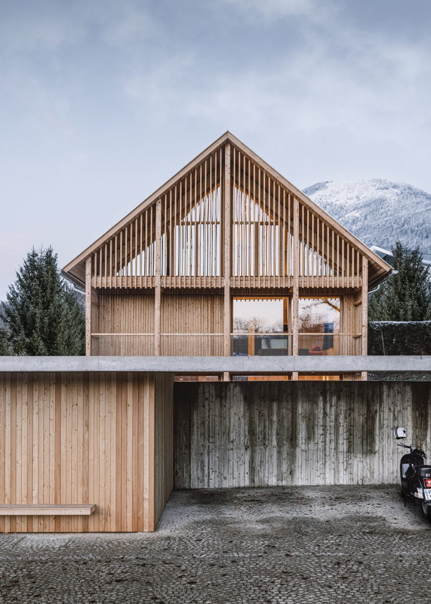 Timber alpine house by Dunkelschwarz in front of Austrian mountain and trees
