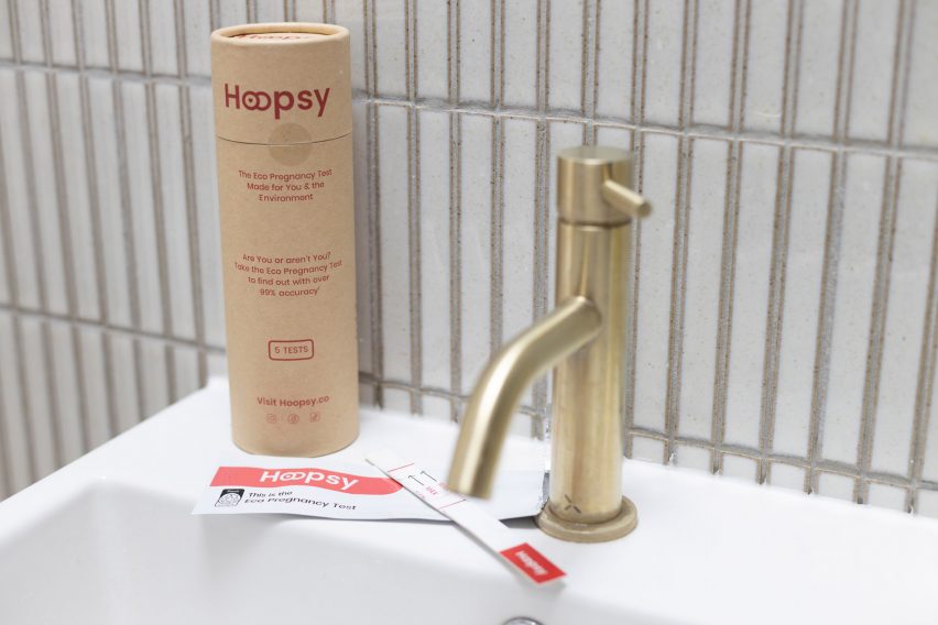 Hoopsy paper pregnancy test and its packaging sitting on the side of a bathroom sink