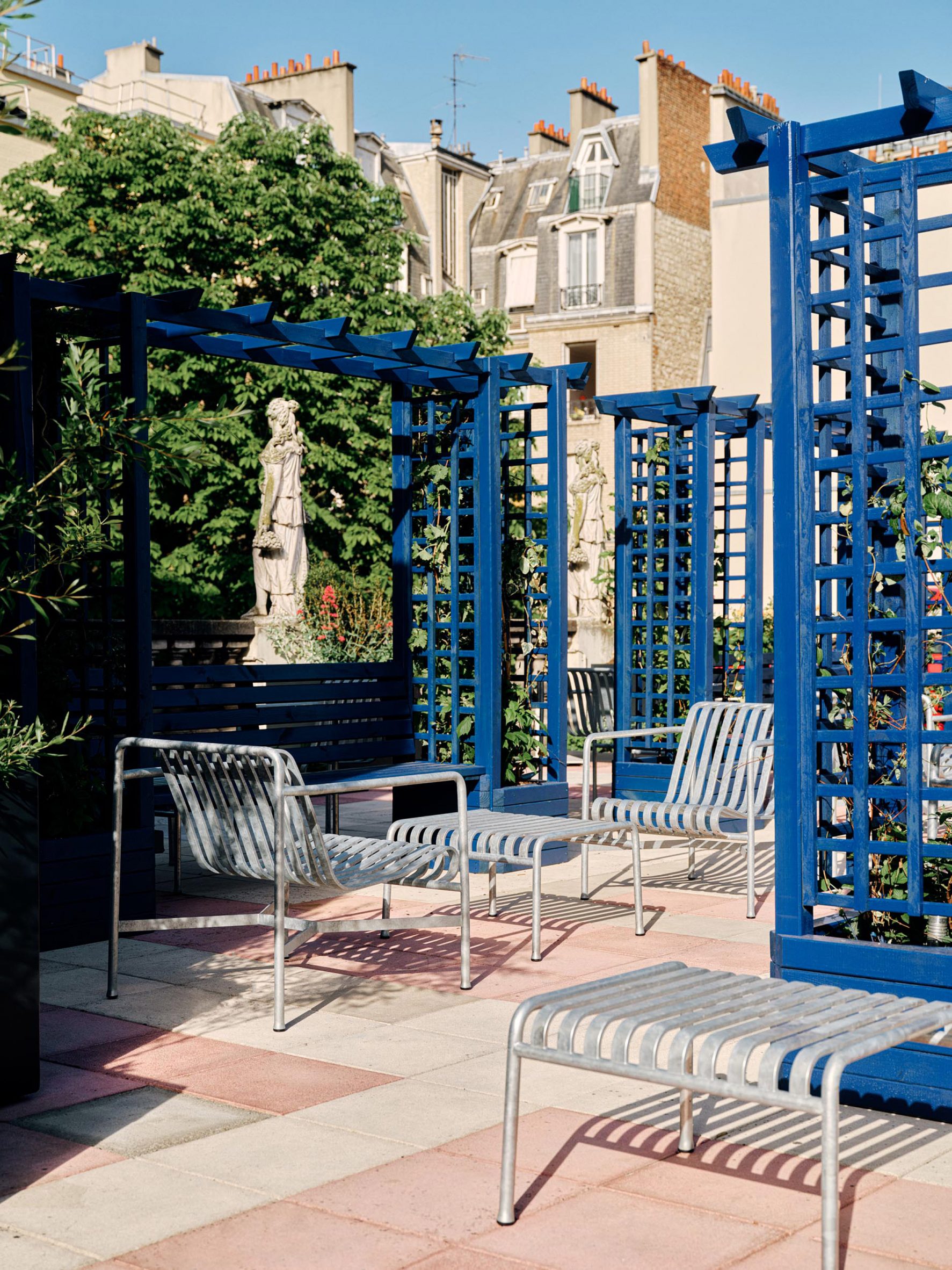 Secret garden area in Parisian courtyard hotel with metal furniture and trees