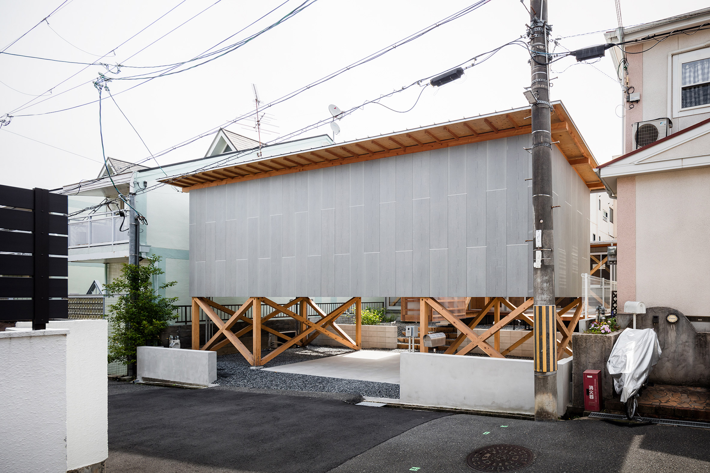 Rectangular grey house elevated on timber supports in Japan