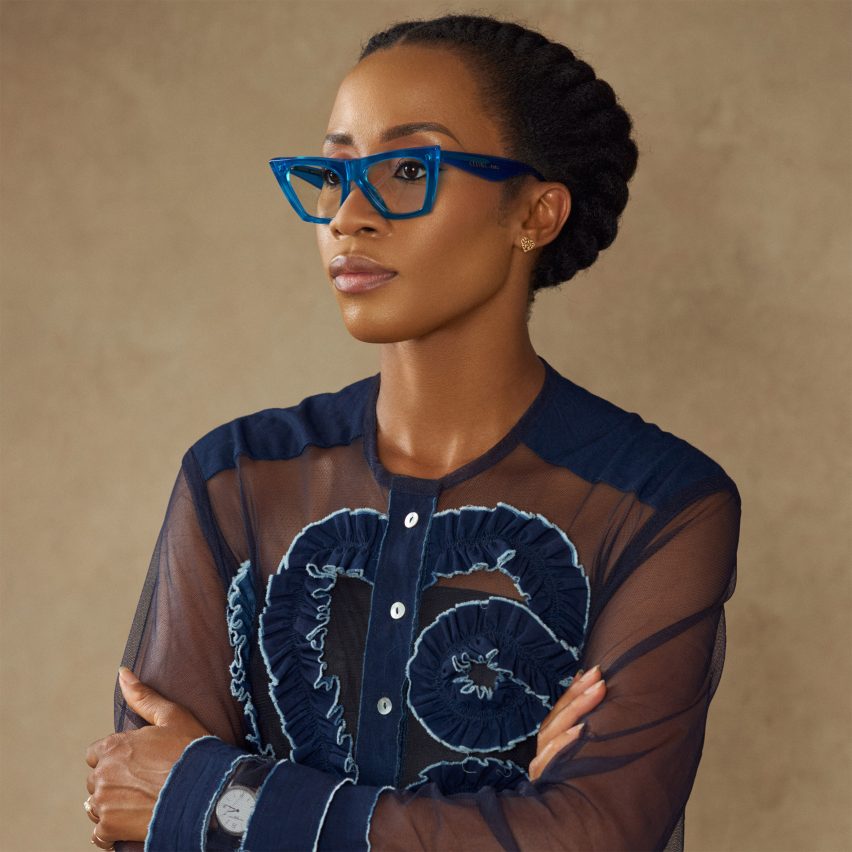 Portrait of Tosin Oshinowo wearing blue glasses and a blue shirt