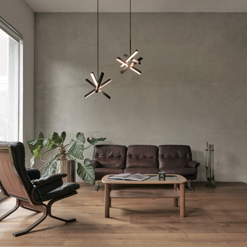 Two Konnect pendant lamps in a neutral-toned living room with brown sofa and armchair