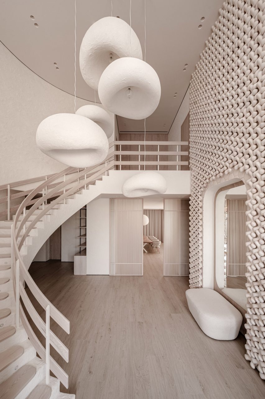 Foyer of Mureli House with sweeping staircase and wall of 3D ceramic tiles